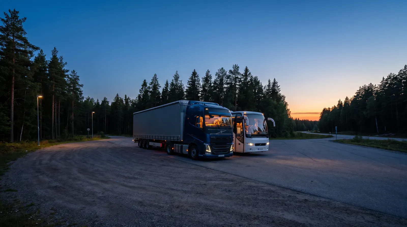 Lastbil och buss parkerade på en rastplats i skymningen